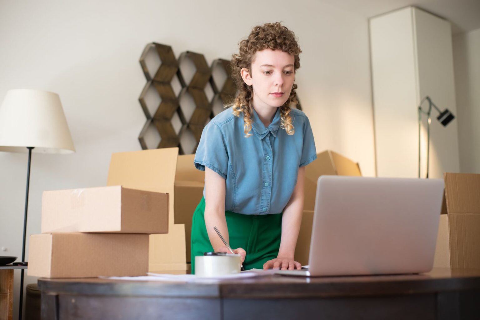 E-commerçante à son ordinateur au milieu des colis