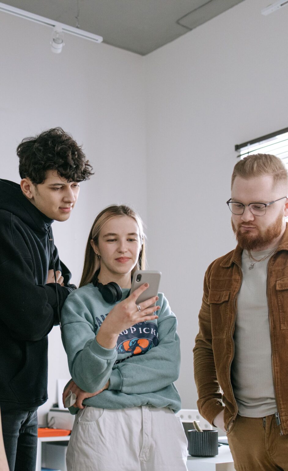 Trois collègues regardent une publication sur un smartphone